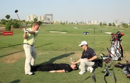 Louis Oosthuizen holds a tee over the face of Rory McIlroy as trick shot expert David Edwards hits a full drive during the Dubai World Championship © Getty Images