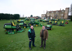 Rochford Hundred course manager Dave Rand (left) and dealer Neil Peachey of Tuckwell with the John Deere fleet, and Rochford Hall in the background.