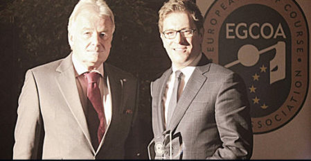 Ian Randell holds the award that has just been presented by Alexander Baron von Spoercken