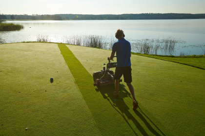 Mowing on dewy green 