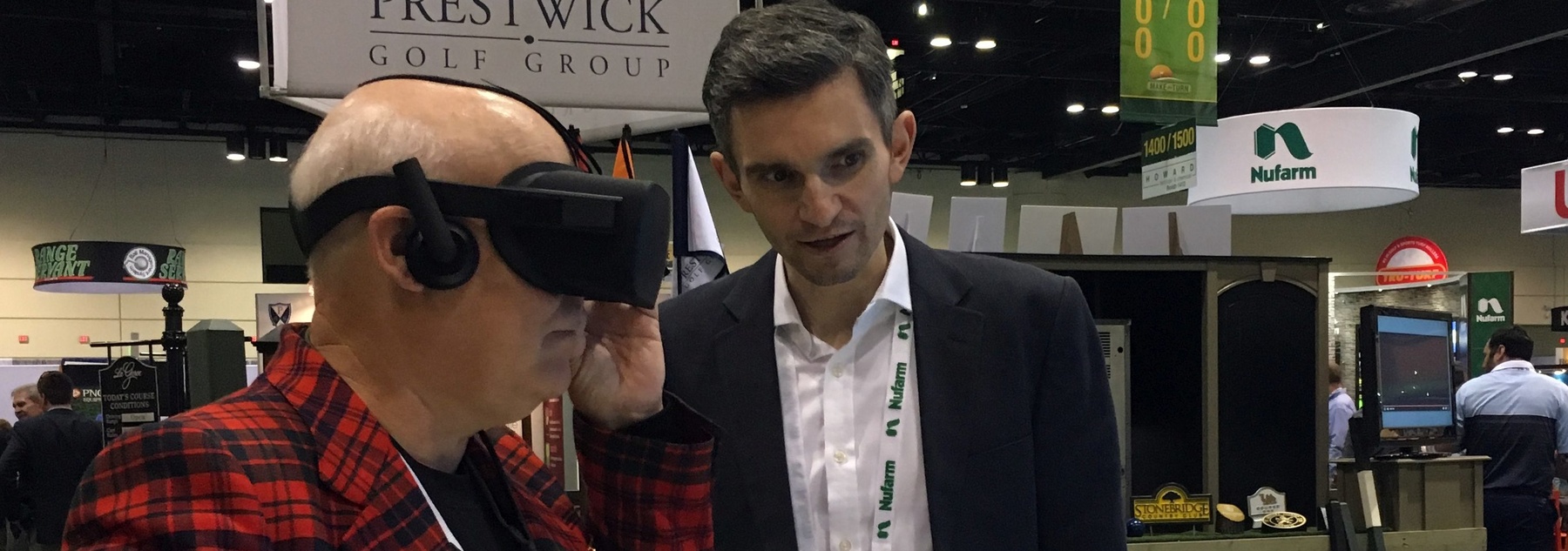 Harris Kalinka director Andrew Harris, right, giving golf course architect Forrest Richardson a demonstration of virtual reality at the Golf Industry Show in Orlando