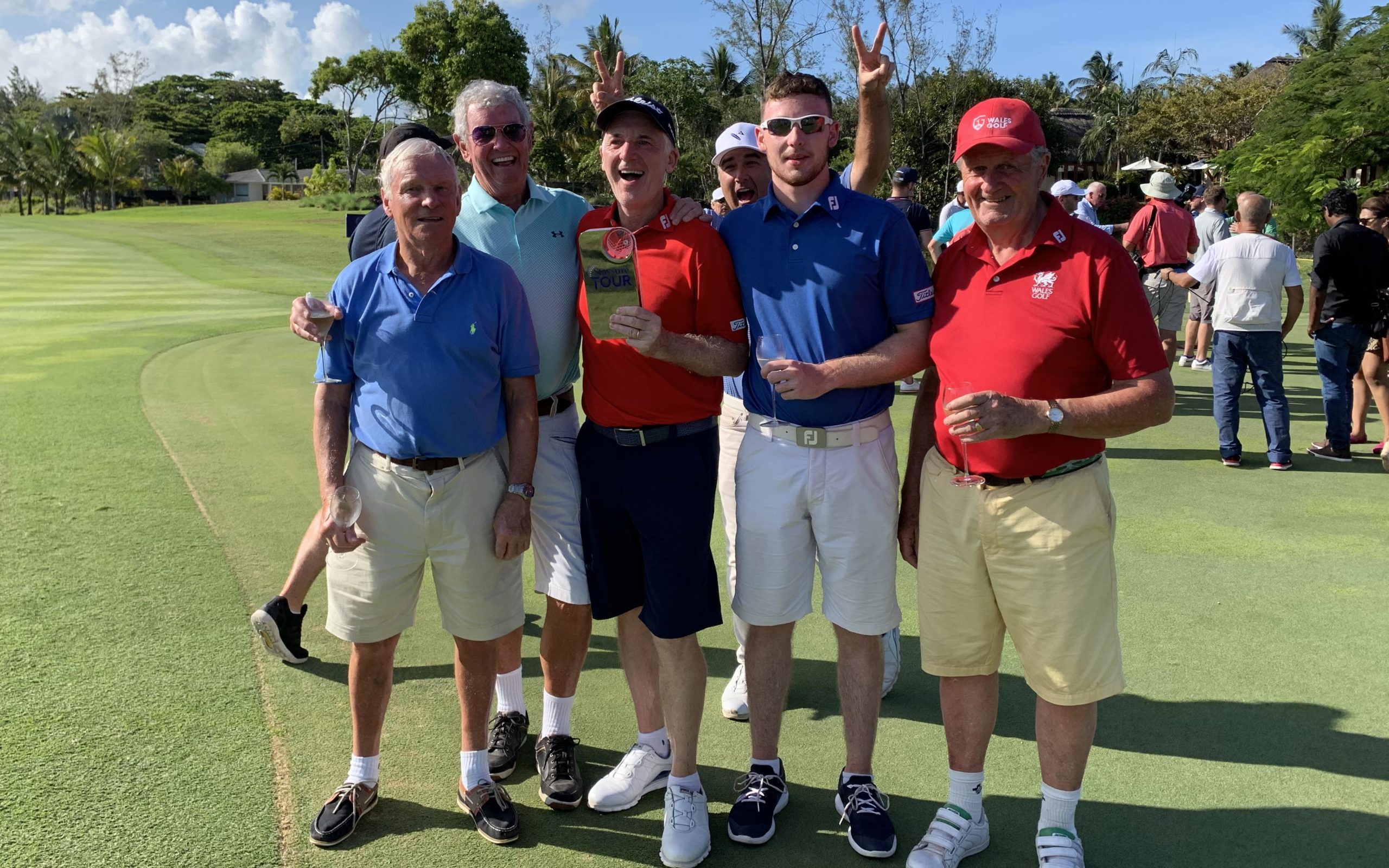 Phil Price celebrates with son and caddy Edward, Wales Golf past-president Jeff Harries and others