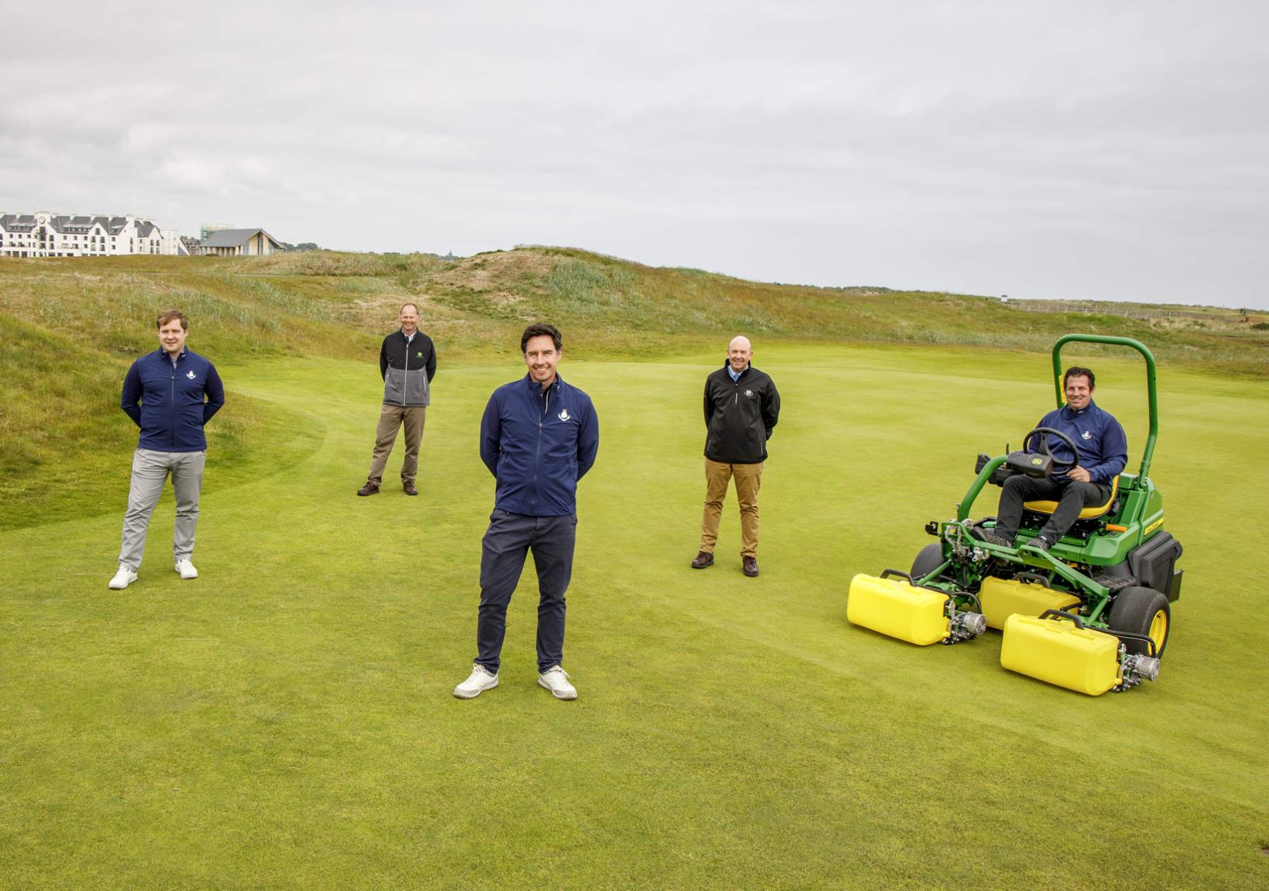 Carnoustie Golf Links Chief Executive Michael Wells (centre front) with (left to right) Deputy Chief Executive Adair Simpson, John Deere Strategic Account Manager Richard Charleton, Managing Director Sandy Armit of John Deere dealer Double A and Links Superintendent Craig Boath, seated on the new John Deere 2750 E-Cut hybrid electric greens mower