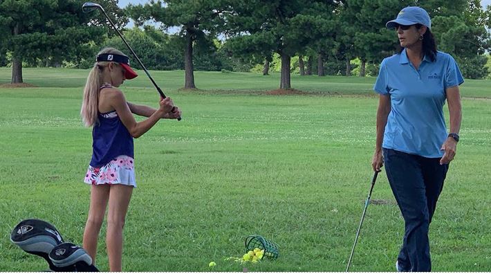 Cathy Harbin, owner of Pine Ridge Golf Course in Texas, takes a golf lesson in a local park