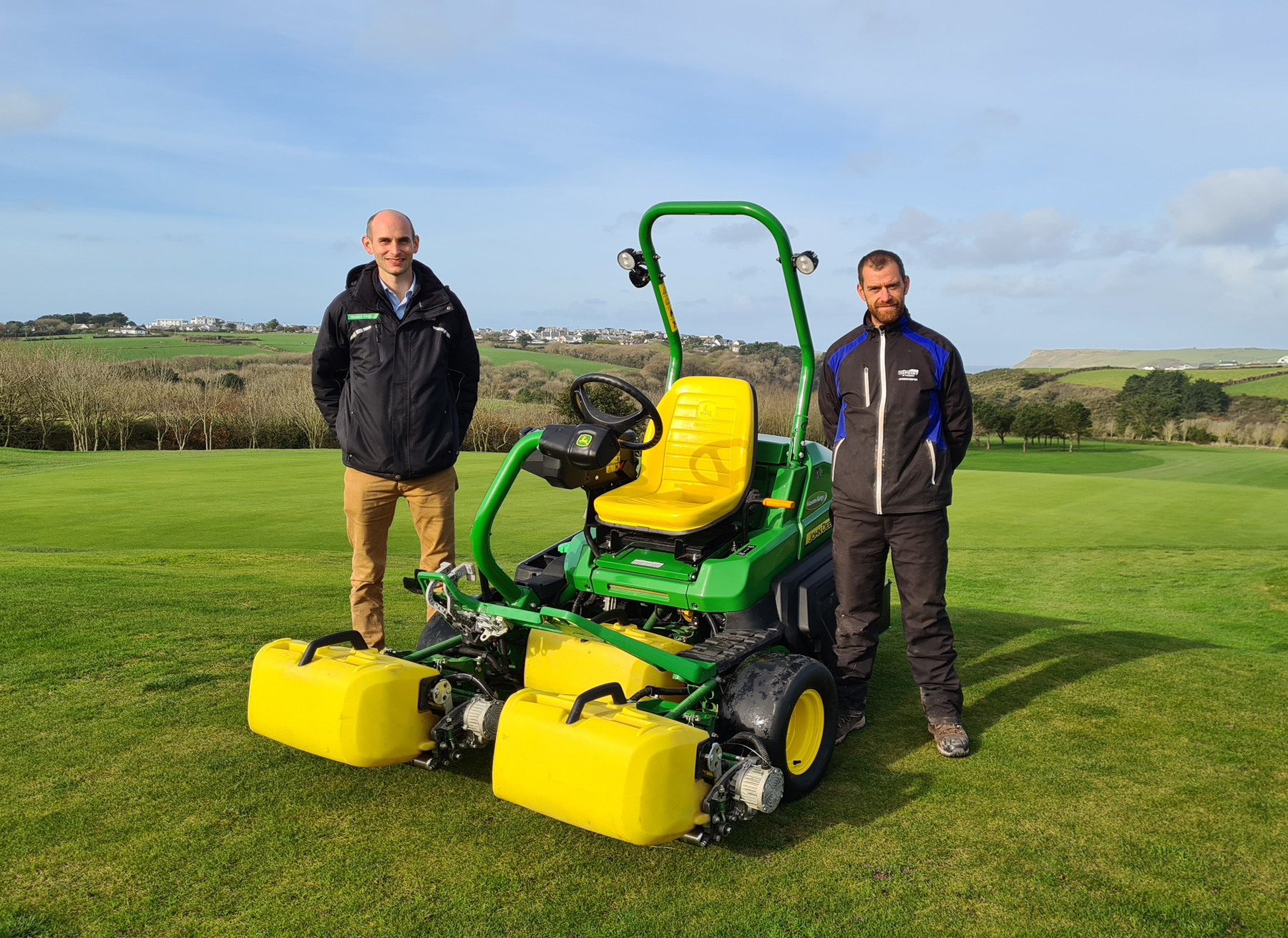 The Point at Polzeath’s head greenkeeper Tom Collings (right) with dealer David Barnes of Masons Kings and the new John Deere 2750E hybrid mower