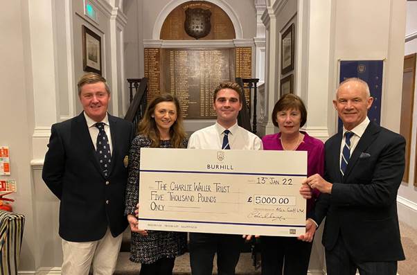 Connor Kelly (centre) receives a £5,000 cheque from Burhill Golf's CEO Colin Mayes to take his total raised for the Charlie Waller Trust to £50,000