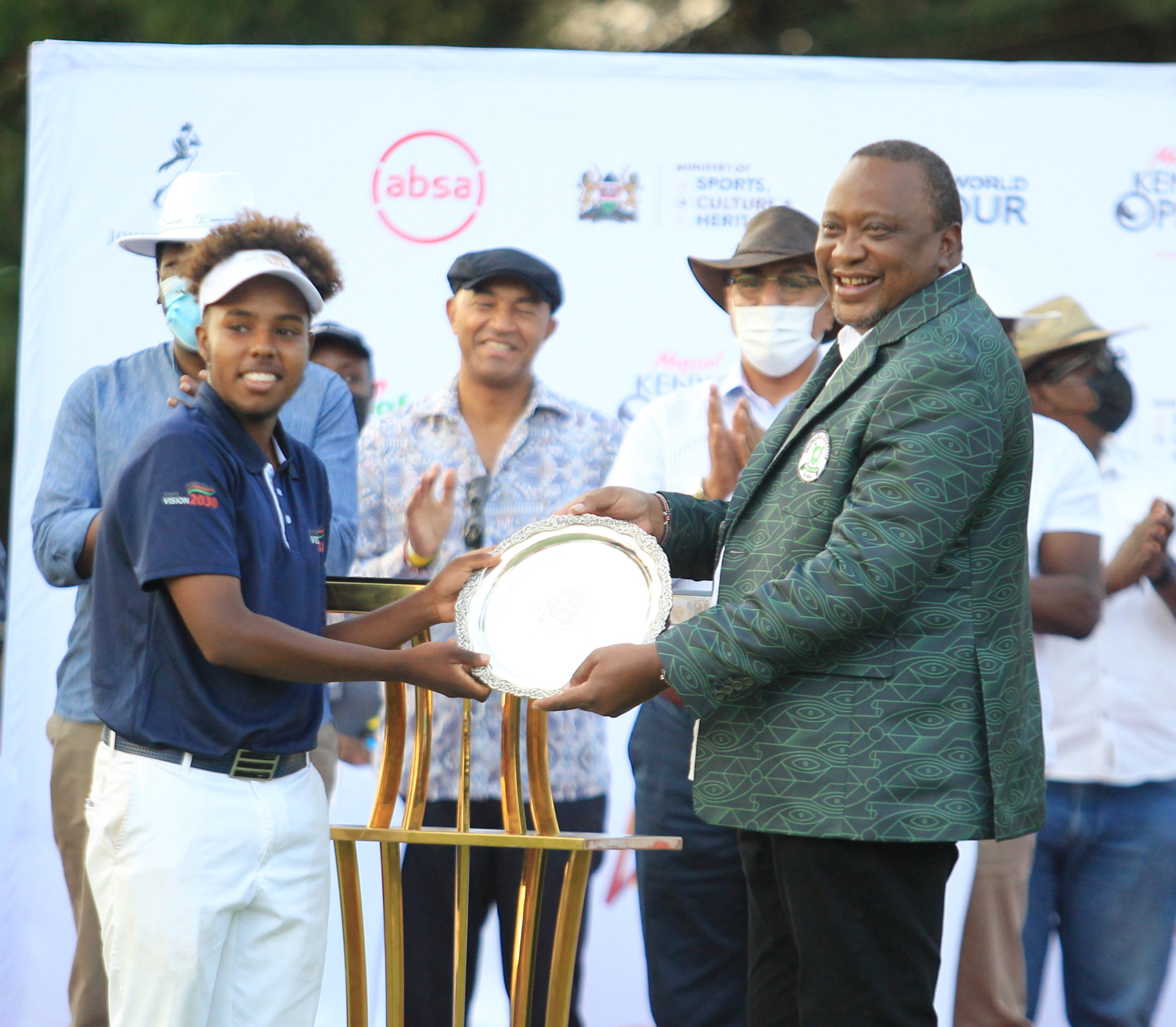 President Uhuru Kenyatta presents the prize for top amateur at the Magical Kenya Open to 18-year-old Kenyan Njoroge Kibugu 