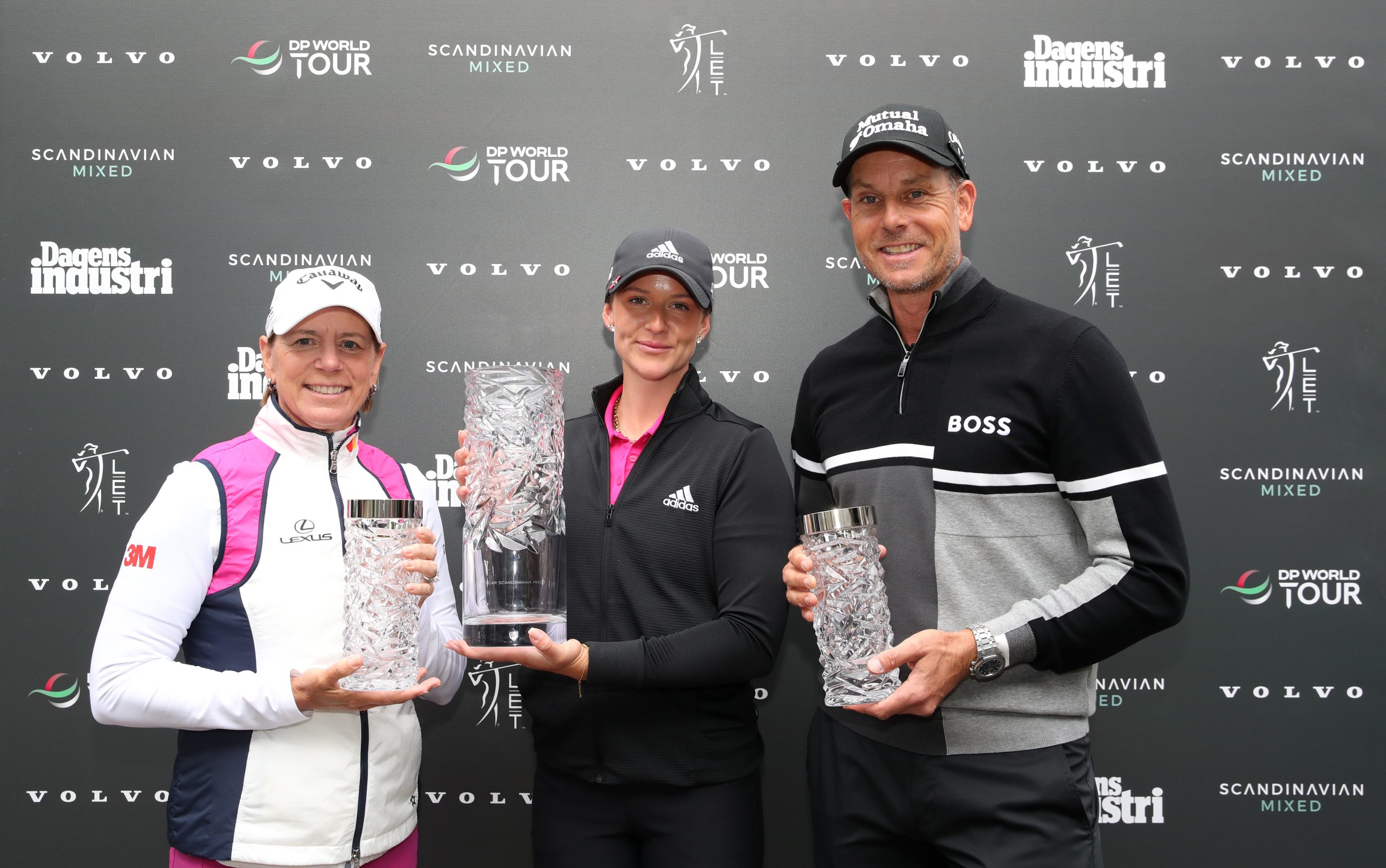 Linn Grant of Sweden is presented with the trophy by tournament hosts Annika Sorenstam and Henrik Stenson after victory at Volvo Car Scandinavian Mixed Hosted by Henrik &amp; Annika