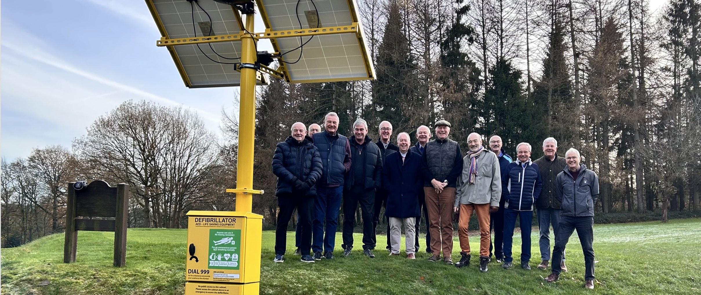 Woodsome Hall's Wastrels gather at the recently installed defibrillator next to the 14th tee