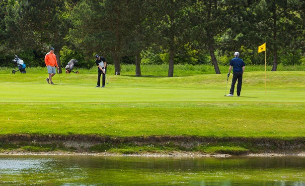   Golfers putting out on the green at Belton Woods  