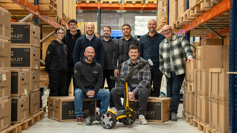 Stewart Golf CEO Mark Stewart (front left) and The Loop partner Paul O'Hagan (front right) with staff and partners from both companies at Stewart Golf's headquarters in Gloucester 