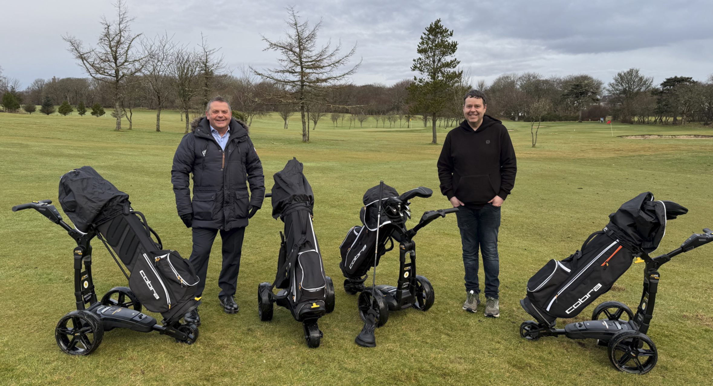 Gordon Jamieson, CEO of NHS Western Isles with Stephen Moar, captain of Stornoway Golf Club, pictured with part of the new rental electric trolley fleet (photo courtesy of the Western Isles Health Board)