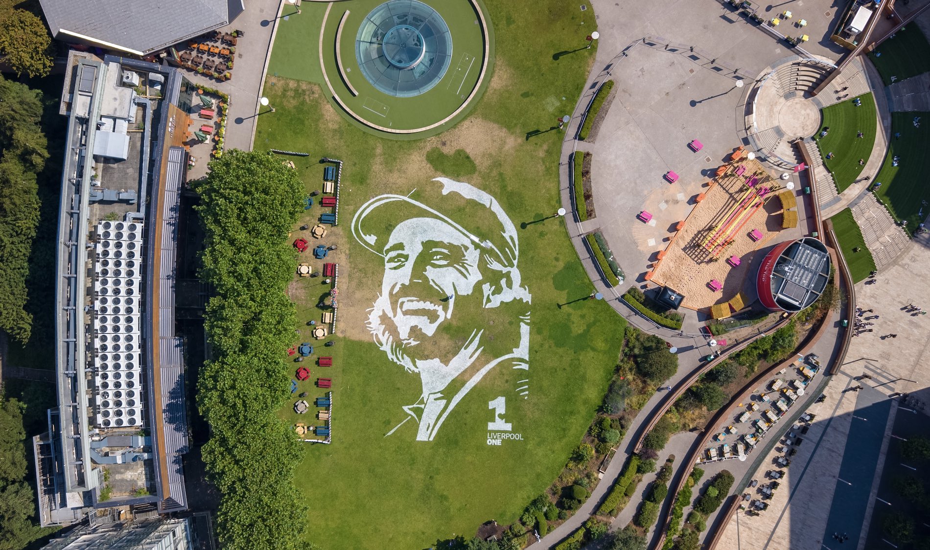 An aerial view of a painting of Tommy Fleetwood which has been etched into the grass outside Liverpool One shopping centre